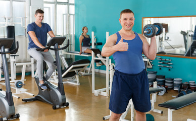 Sporty guy doing exercises with dumbbells