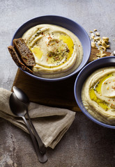 mashed cauliflower with cashew nuts in plates on the table with rye bread . healthy winter cooking, vegan recipe for the whole family or dinner with friends