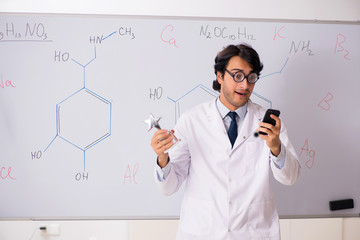 Young funny chemist in front of white board 