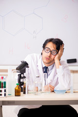 Young funny chemist in front of white board 