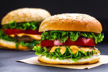 Delicious fresh homemade burgers on a dark background. Fast and bad food