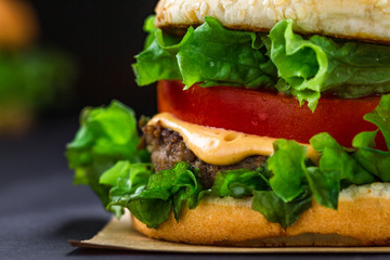 Delicious fresh homemade burger on a dark background. Fast and bad food