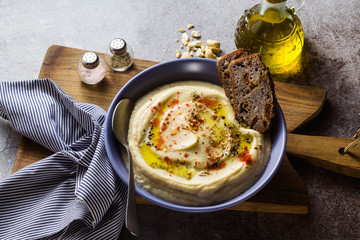 mashed cauliflower with cashew nuts in plates on the table with rye bread . healthy winter cooking, vegan recipe for the whole family or dinner with friends