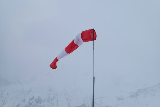 Ein etwas schlaffer Windsack im Schneetreiben an der Bergstation des Fellhorns in Oberstdorf
