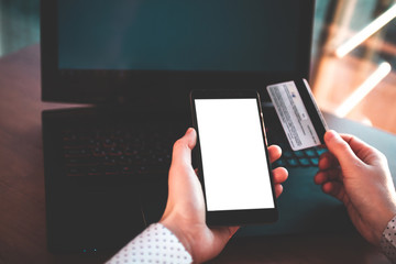 Using a laptop, credit card and mobile phone to buy and payment goods. Online shopping. Money transfer to people in need, charity, investment