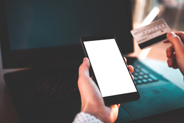 Using a laptop, credit card and mobile phone to buy and payment goods. Online shopping. Money transfer to people in need, charity, investment