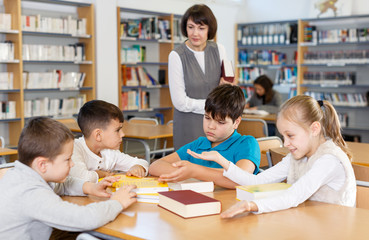 School kids studying with female teacher