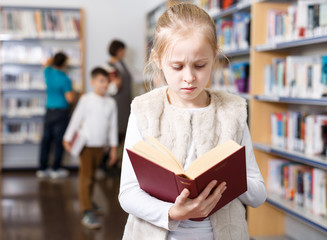 Preteen girl browsing textbook