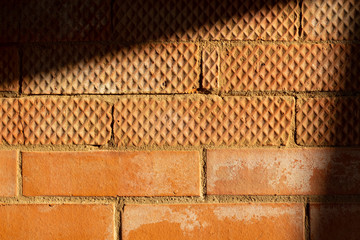 Wall of red smooth and ribbed bricks