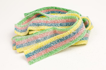 heap of striped gummy candy in blue, green, red and yellow