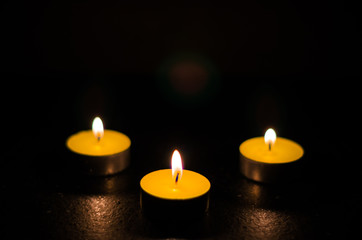 Obraz na płótnie Canvas Three burning candles isolated on black background.