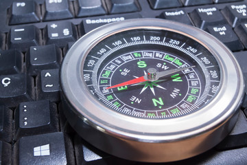 Fototapeta premium compass over a black computer keyboard