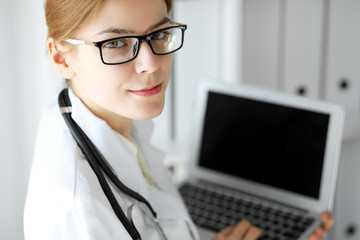 Doctor woman at work. Portrait of female physician using laptop at hospital office. Medicine and healthcare concept