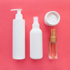 Skincare Photo mockup Different white cosmetic bottles, flacons and jars on bright pink background Flat lay