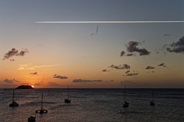 Plane in the sky over the sunset in anse Mitan, Les Trois-Ilets, Martinique FWI