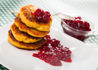 Stack of sweet  fried quark pancakes with  with tasty berry jam