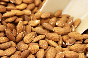 Almond nuts and scoop, selective focus. Raw almonds on the market