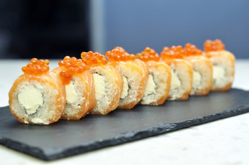 Philadelphia roll sushi with salmon, smoked eel, cucumber, avocado, cream cheese, red caviar. Sushi menu. Japanese food.