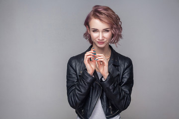 Portrait of cheater beautiful girl with short hairstyle, makeup in casual style black leather...