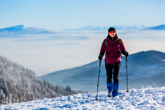 Woman trekking traveler with backpack hiking in Beskidy mountains at sunny day, adventure concept active vacations with outdoor activity on snow in the forest, Poland- Image