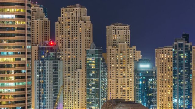Dubai marina and JBR twers panorama day to night transition timelapse lights turn on. The night illumination of skyscrapers, UAE. Aerial view from JLT