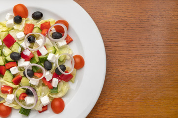 half a plate of salad on a wooden table. restaurant menu. vegetarian cuisine