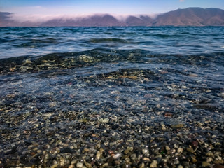 Obraz premium Armenia, lake Sevan, water, sky, coast, nature,, landscape, blue, rock, wave, horizon, summer, travel, sun, stone, sunrise, coastline, cloud, clouds, beauty, rocks, shore