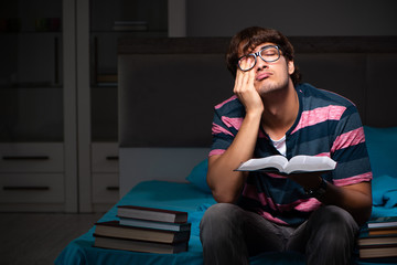 Obraz premium Young handsome student preparing for exams at night
