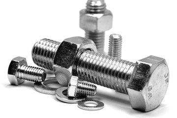 Metallschrauben mit Muttern und Unterlegscheiben vor weißem Hintergrund