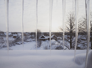 Icicles on winter village background