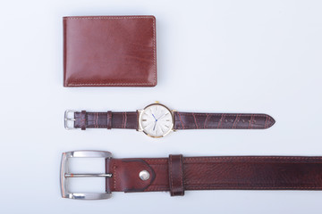 Men's accessories for business and rekreation. Leather belt, wallet, watch and smoking pipe on white background.. Top view composition.