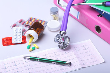 Close-up stethoscope lying on RX prescription with assorted pills. Healthy life or insurance...