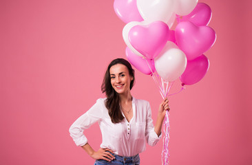 Happy beautiful cute lovely woman with colorful balloons and gift in hands is have a fun and celebration. Birthday, Holidays, St Valentines day and other