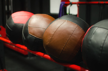 Big leather crossfit balls on the rack in the gym.