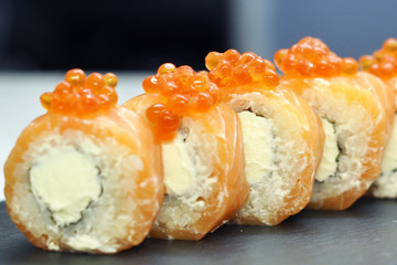 Philadelphia roll sushi with salmon, smoked eel, cucumber, avocado, cream cheese, red caviar. Sushi menu. Japanese food.