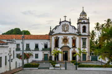Fototapeta na wymiar The historic architecture of Olinda in Pernambuco, Brazil showcasing The Mosteiro de Sao Bento church with its Baroque facade and cobble stone pathway on a sunny day.
