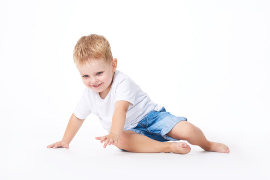 Cute boy plaing with toy car on floor, isolated on white