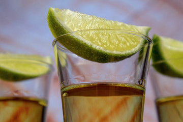 Gold tequila shot and lime slices