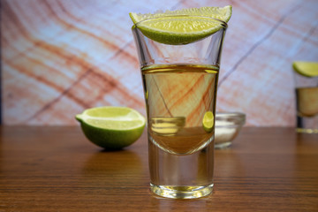 Gold tequila shot and lime slices