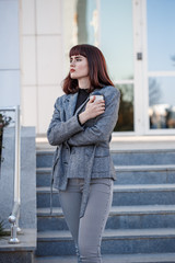 Fototapeta premium Young beautiful caucasian business woman on the street with coffee after work.