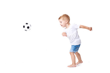 Little cute kid baby boy 3 years old, football fan in white t-shirt playing with soccer ball isolated on white background.  lifestyle concept. Copy space for text