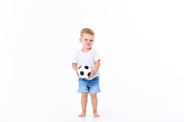 Little cute kid baby boy 3 years old, football fan in white t-shirt playing with soccer ball isolated on white background.  lifestyle concept. Copy space for text