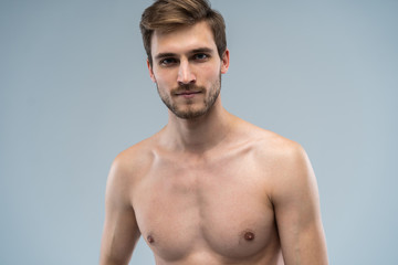 Fototapeta premium portrait of attractive confident concentrated focused seductive guy with ideal face features bearded with stylish trendy hairdress isolated on gray.