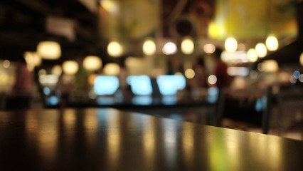 Blurred a wooden dinning table in the room area with warm bokeh light in the dark night  - obrazy, fototapety, plakaty