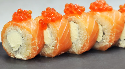 Philadelphia roll sushi with salmon, smoked eel, cucumber, avocado, cream cheese, red caviar. Sushi menu. Japanese food.