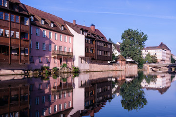 A number of houses stand on the banks of the Pegnitz River in Nuremberg Germany.