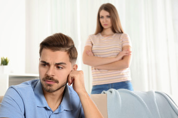 Fototapeta premium Young couple arguing in living room. Relationship problems