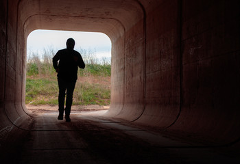 man running through dark tunnel escaping