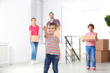 Happy family with moving boxes in their new house