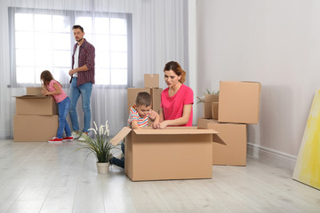 Fototapeta na wymiar Happy family unpacking boxes in their new house. Moving day
